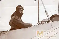 Photo montrant Jean Desparmet, en tenue d'aviateur, à bord d'un avion. Il regarde l'appareil photo.
