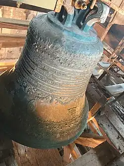 Cloche avec des inscriptions gravées.