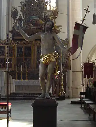 Statue de Jésus tenant l'étendard qui indique sa résurrection suivant le symbolisme chrétien.