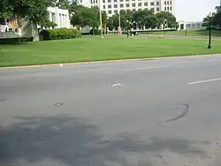 Elm Street. Le X peint sur la chaussée marque l'endroit où Kennedy a reçu le tir mortel.