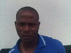 visage d'un homme noir portant un polo bleu