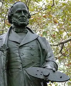 Photo de la statue de John Ericsson érigée à la Battery, New York, tenant une maquette du Monitor à la main