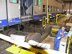 L'atelier comprend un vérin en fosse, qui permet de déposer un bogie afin d'assurer son entretien. Ici, le bogie est en cours de déplacement latéral sur le vérin, après sa séparation de la voiture par une translation verticale.