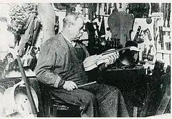 Joseph Hel dans son atelier, photo exposée au Musée de l'Hospice Comtesse à Lille entre le 2 décembre 1989 et le 2 avril 1990, pour le centenaire de l'exposition universelle de Paris de 1889