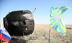 Le module de descente en grande partie carbonisé après son retour.