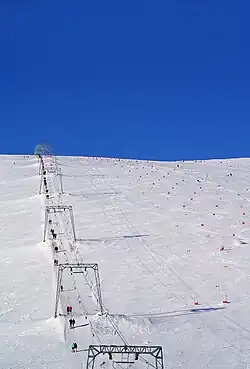 Remontée mécanique sur un paysage enneigé.