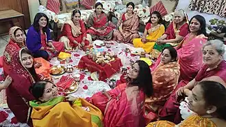 Femmes à jeun assises en cercle, tout en faisant la puja de Karva Chauth.