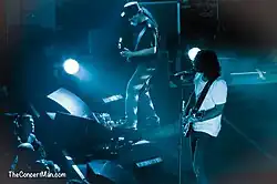 Photographie de deux guitaristes en concert