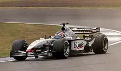 Photo vue de côté gauche d'une monoplace noire et argentée en piste