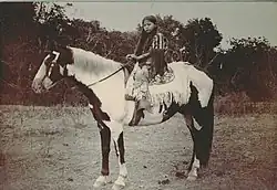 Adolescente à cheval vue de profil.