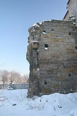 Photographie couleur d'une mur de pierres de taille sous la neige.
