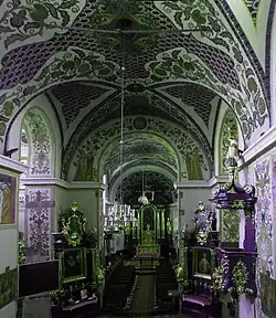 Photographie couleur d'un nef d'église dont les voûtes sont peintes.