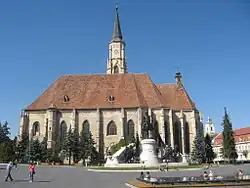 Place de l'Union avec l'église Saint-Michel et le groupe statuaire du roi Matthias Corvin réalisé par János Fadrusz au début du XXe&nbsp;siècle.