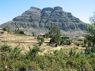 Photographie d'une montagne rocheuse avec un sommet plat.