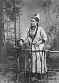 Femme en costume d'inspiration sami, photographie de studio devant une toile peinte, 1885-1892.