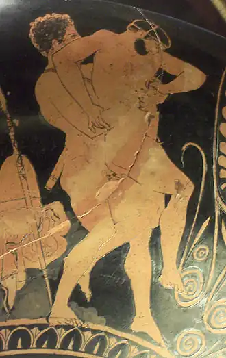 Vase antique à fond noir : deux hommes luttant.