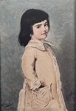 Portrait d'une fillette aux cheveux noirs de trois quarts, portant une robe claire et avec la main droite dans la poche de sa robe.