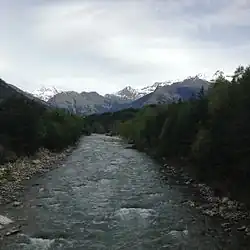 La rivière l'Arc, vue vers l'amont, bordée d'arbre.