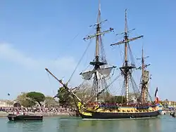 La frégate Hermione sortant du bassin des chalutiers pour accéder au chenal.