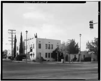 Photographie en noir et blanc d'un large boulevard entouré de quelques bâtiments.