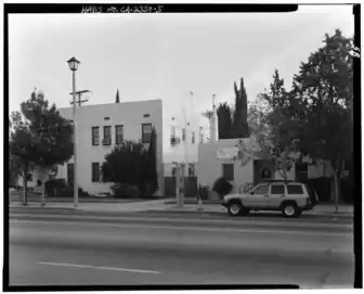 Photographie en noir et blanc d'un large boulevard entouré de quelques bâtiments.