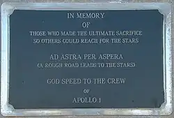 Une plaque en marbre noir, sur laquelle on peut lire "In memory of those who made the ultimate sacrifice so others could reach for the stars. AD ASTRA PER ASPERA (A rough road leads to the stars). God speed to the astronauts of Apollo 1.