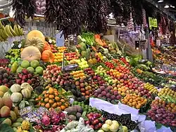 Un étalage de marché, couvert de fruits et légumes.