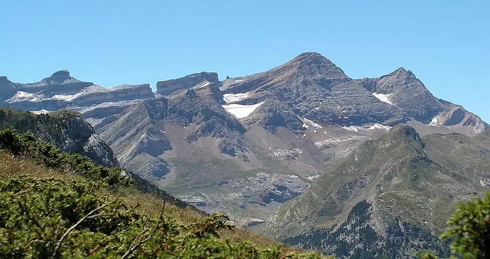 De gauche (à l'est) à droite (à l'ouest), le casque du Marboré (3&nbsp;006&nbsp;m) avec sa forme caractéristique, ensuite la brèche de Roland (2&nbsp;807&nbsp;m) qui vient interrompre une pente régulière de la ligne de crête, montant légèrement d'est en ouest, vers la pointe Bazillac (2&nbsp;975&nbsp;m). Puis on trouve une autre brèche, dite la Fausse Brèche (2&nbsp;909&nbsp;m en son point le plus bas), à l'intérieur de laquelle se trouve le « doigt de la Fausse Brèche » (2&nbsp;944&nbsp;m), que l'on entrevoit à peine à cette distance. Ensuite, l'imposant pic du Taillon (3&nbsp;144&nbsp;m) et enfin les pics des Gabiétous (3&nbsp;044&nbsp;m et 3&nbsp;031&nbsp;m) .