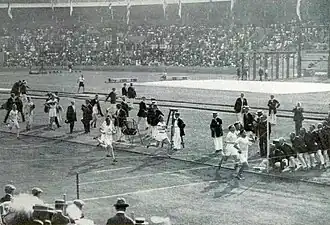 Photo d'athlète courant sur une piste de course.