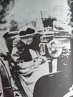 La princesse Charlotte abritée par une ombrelle de couleur claire est promenée en calèche dans son domaine de Bouchout