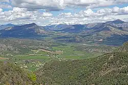 Photo prise d'un point culminant d'une large vallée entourée de montagnes.