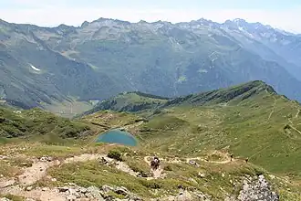 Vue du lac Noir en contrebas du Petit Arc ; au fond, les versants septentrionaux du chaînon de la Lauzière.