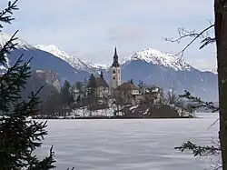 Le lac de Bled gelé en hiver. Au fond à droite, le Begunjščica.