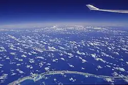 Image aérienne du lagon Bleu (en bas à gauche) avec au loin l'atoll de Tikehau.