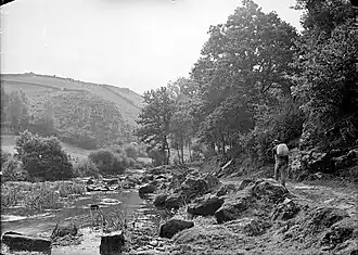 Homme portant un sac sur son dos sur un chemin longeant l'Inam.