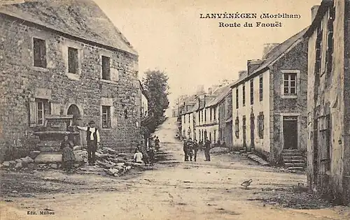 La route du Faouët (actuelle rue Jean Cadic) au début du XXe siècle avec au premier plan le vieux puits aujourd'hui disparu (carte postale Milliou).
