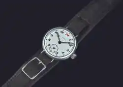 Photographie d'une montre à bracelet noir et cadran blanc