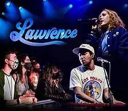 Montage de quatre photographies prises lors d'un concert de Lawrence à The Novo (Los Angeles) en 2021. De haut en bas et de gauche à droite : logo du groupe éclairé par les lumière de la scène, Gracie Lawrence chantant dans un micro, le public dont les membres portent des masques anti-Covis, Clyde Lawrence jouant du clavier.
