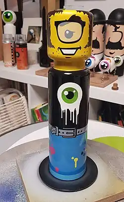 Autoportrait en L'ego. Potelet anti stationnement en acier peint à la bombe aérosol et pochoirs. Hauteur : 30 cm - Diam. : 10 cm