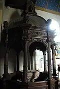 Cuve baptismale aux serpents sous son baldaquin.