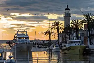 Un bateau de pêche rentrant au port au soleil couchant.