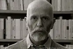 Portrait en noir et blanc, en gros plan sur le visage, d'un homme barbu, de face.