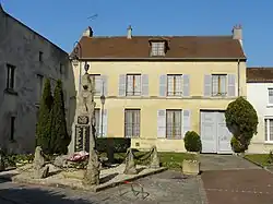 Monument aux morts et maison, rue de Paris