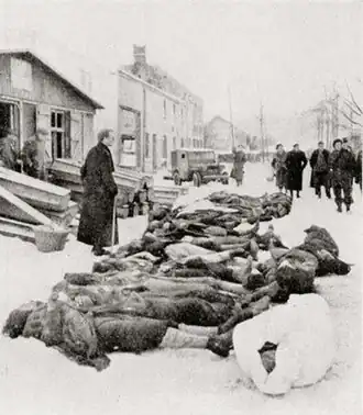 Le père Musty devant les dépouilles des 34 civils.