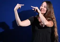 Femme aux cheveux longs en train de s'exprimer en langue des signes