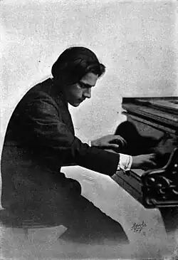 Photographie en noir et blanc, datée de 1914, d'un homme jouant du piano