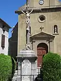 Statue du Christ en croix devant l'église.