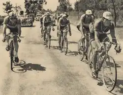 Photo en noir et blanc de sept cyclistes en échappée.