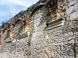 Photographie en couleurs montrant la juxtaposition de pierres de taille sculptées et d'autres brutes.