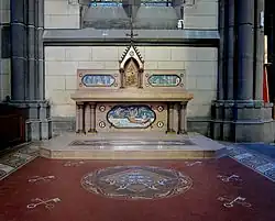 Photographie en couleurs du pavement et de l'autel de la chapelle vu de face.